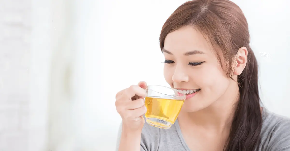 a woman drinking longjing tea