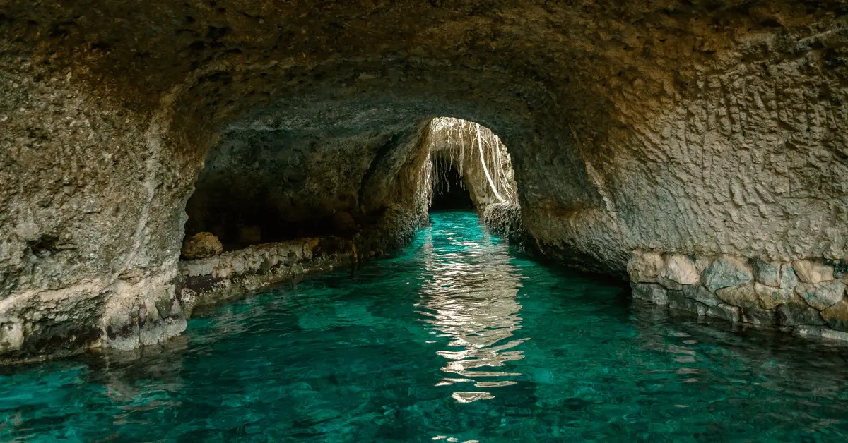 a cave with a turquoise pool in it