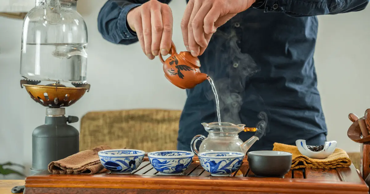 a man pouring tea into a cup