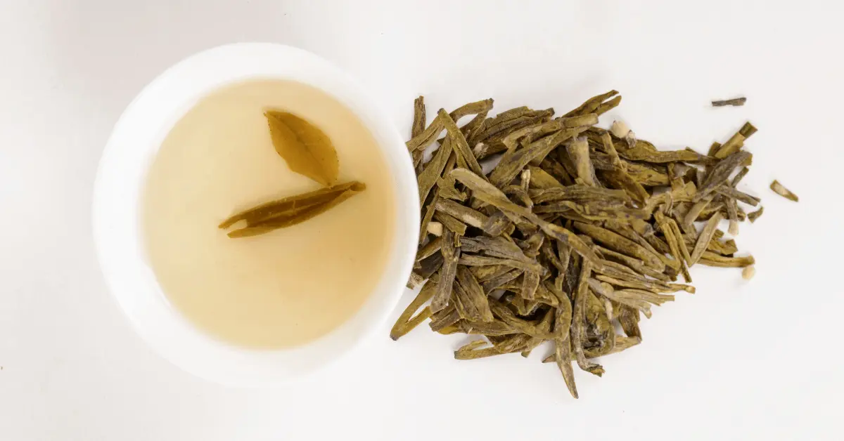 a cup of longjing tea and tea leaves